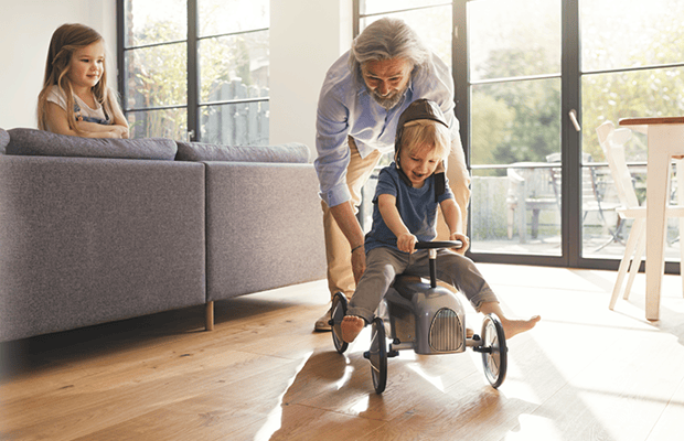 May 2022 Header Man pushing small child on a tricycle