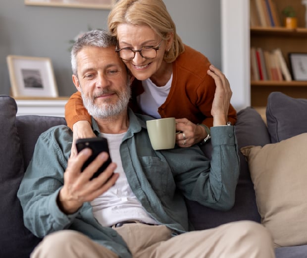 Older couple checking their phone on sofa