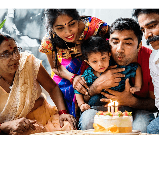 Image of a family blowing out birthday cake candles together.